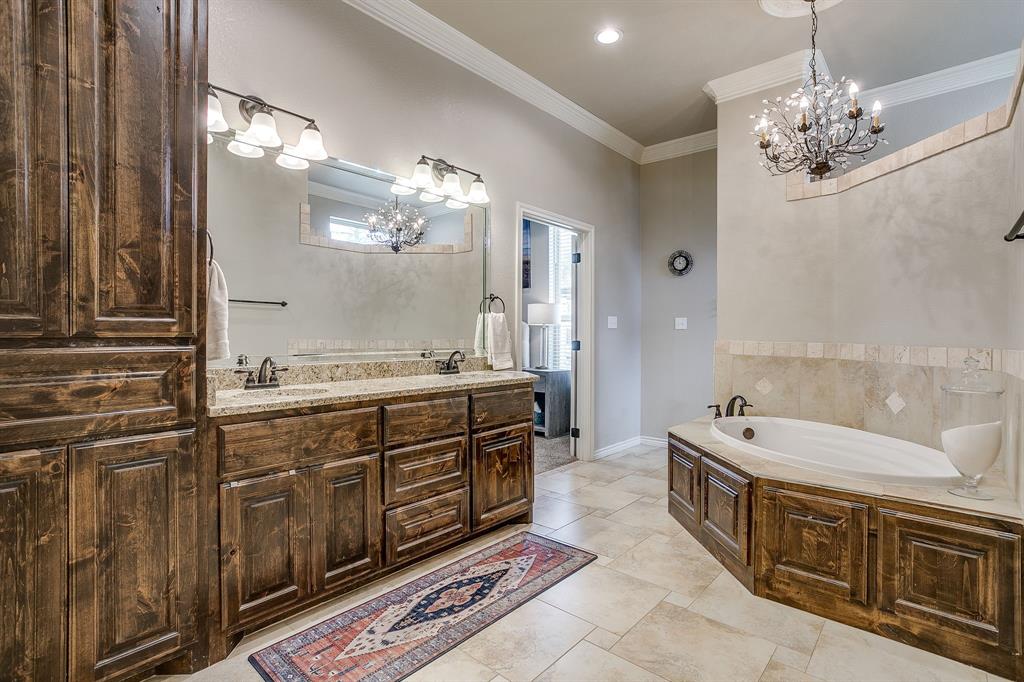1615 Sanger Drive Springtown, TX 76082 - Photo 19 of 40 a spacious bathroom with a double vanity sink large mirror and a bathtub