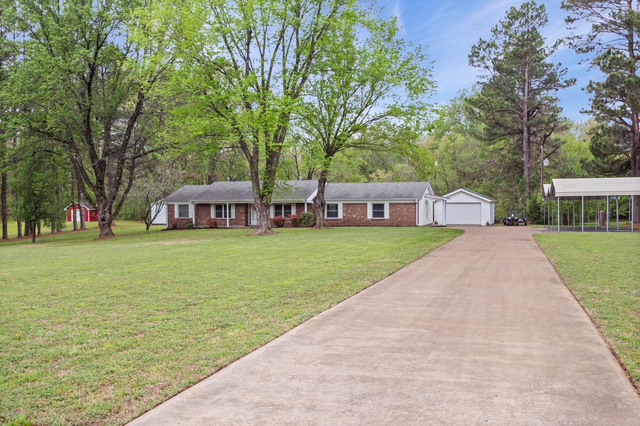 58 Hayes Road Munford, TN 38058 - Photo 1 of 40 Ranch-style house with a front lawn, an outbuilding, driveway, brick siding, and a garage