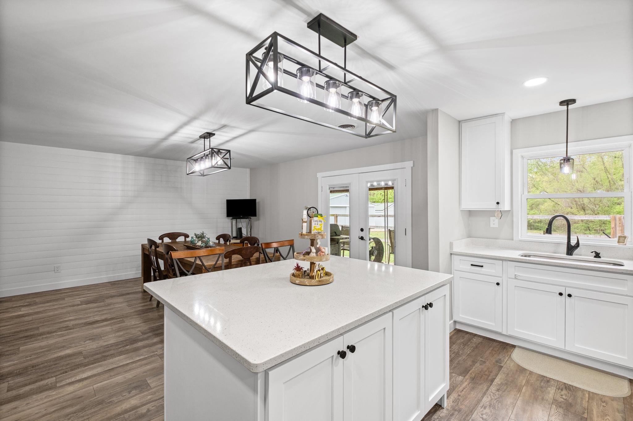 58 Hayes Road Munford, TN 38058 - Photo 11 of 40 Kitchen with hanging light fixtures, white cabinetry, a kitchen island, dark wood-style flooring, and light stone counters