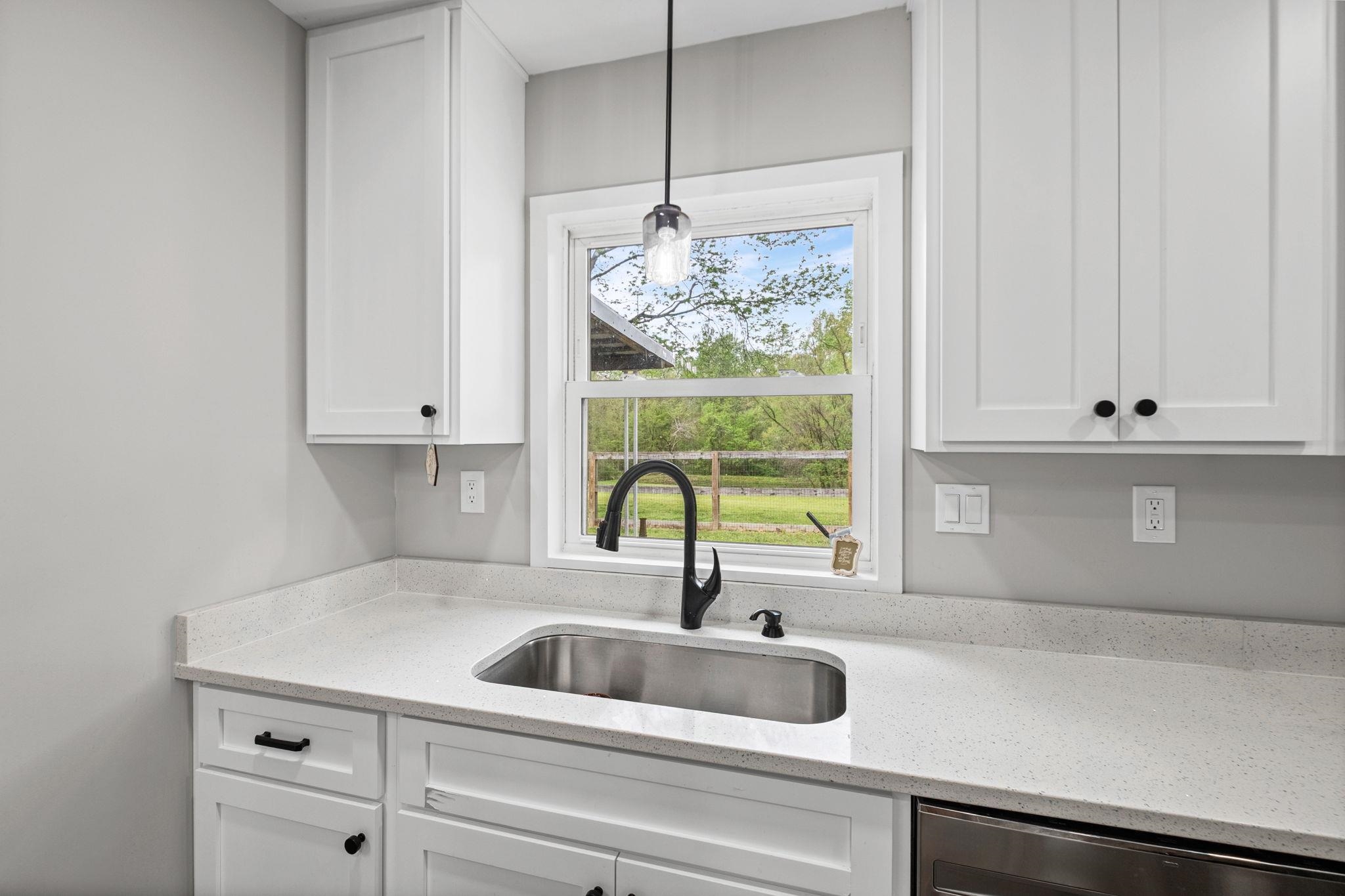 58 Hayes Road Munford, TN 38058 - Photo 15 of 40 Kitchen featuring white cabinetry, light stone countertops, dishwasher, and decorative light fixtures