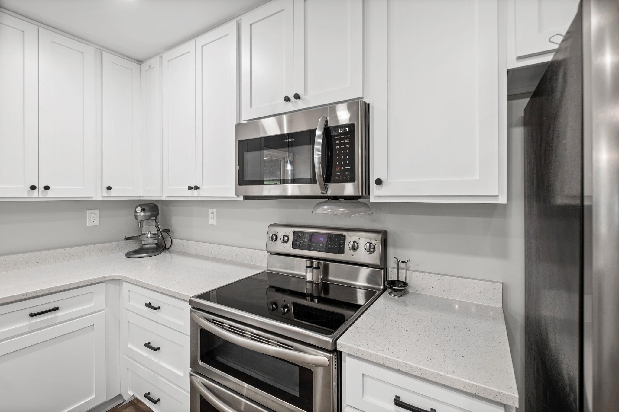 58 Hayes Road Munford, TN 38058 - Photo 16 of 40 Kitchen with stainless steel appliances, white cabinets, and light stone counters