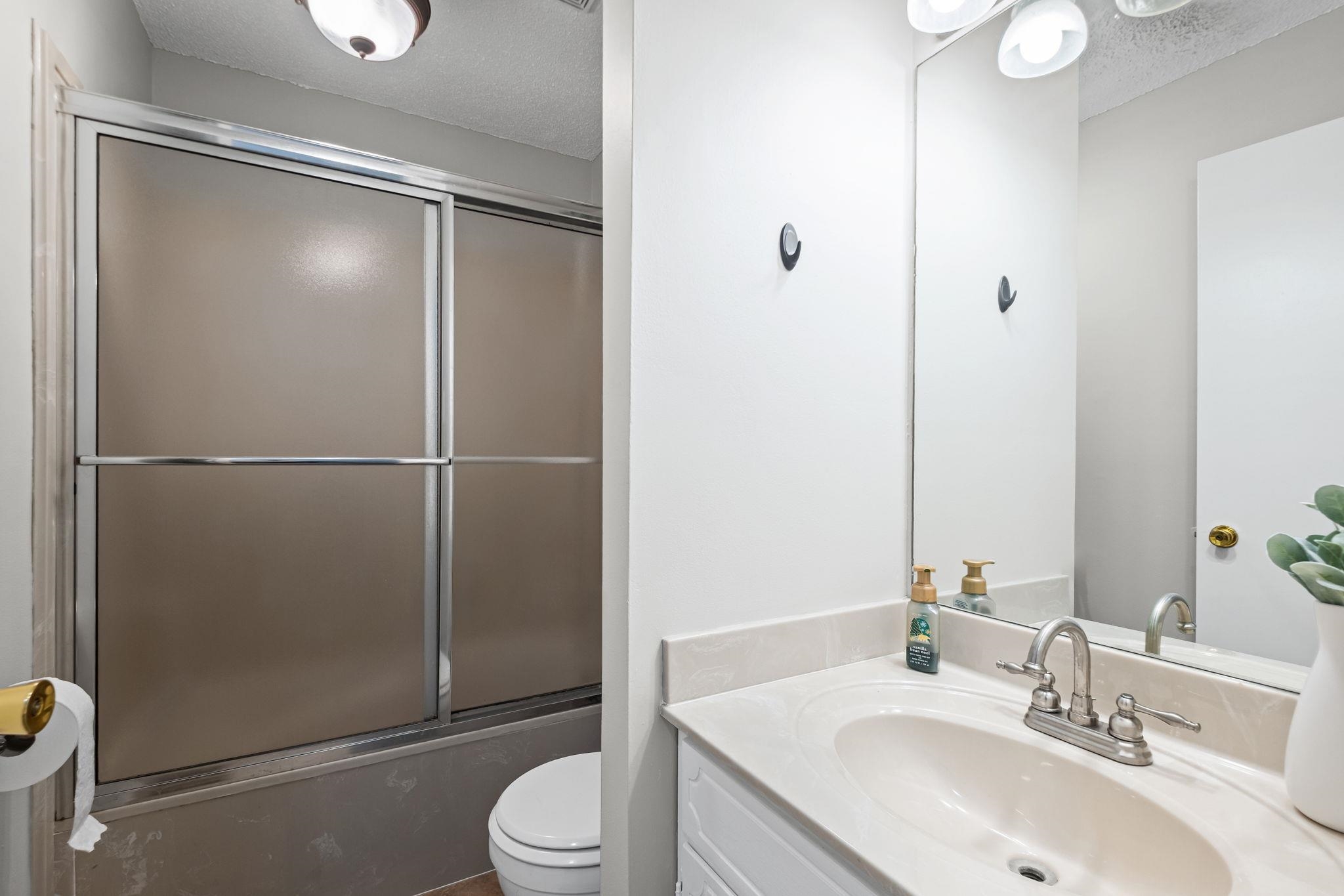 58 Hayes Road Munford, TN 38058 - Photo 30 of 40 Full bath with a textured ceiling, vanity, and combined bath / shower with glass door