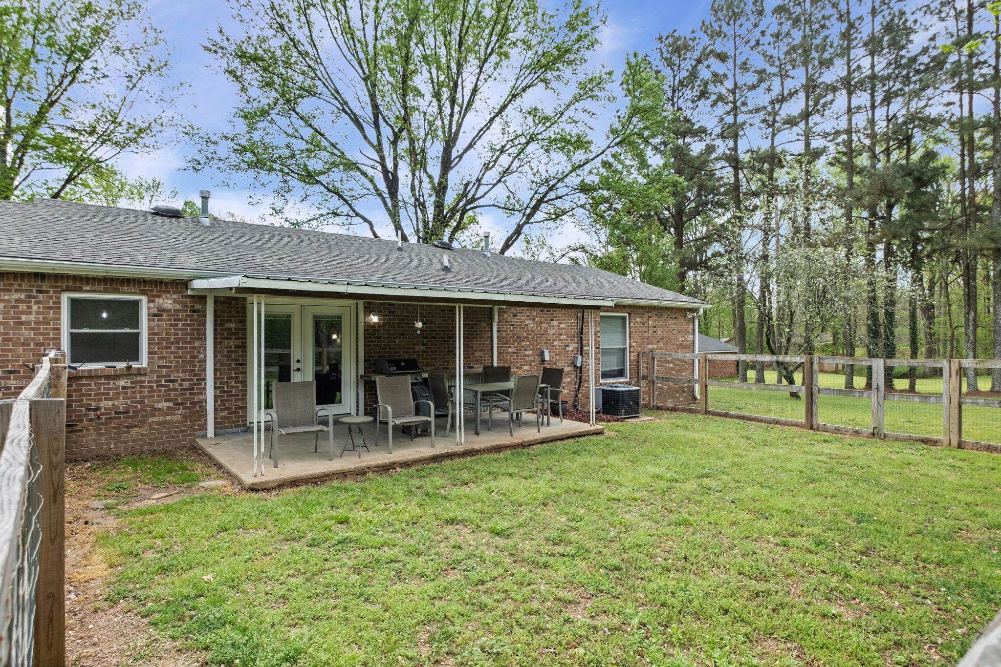 58 Hayes Road Munford, TN 38058 - Photo 37 of 40 Back of property with a fenced backyard, brick siding, roof with shingles, and a patio