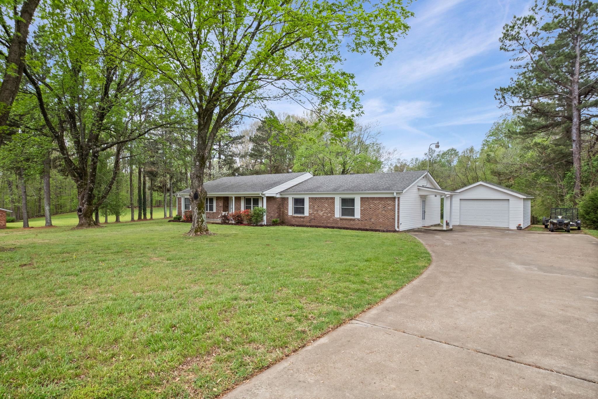 58 Hayes Road Munford, TN 38058 - Photo 4 of 40 Ranch-style house with brick siding, a front lawn, an outbuilding, driveway, and a garage