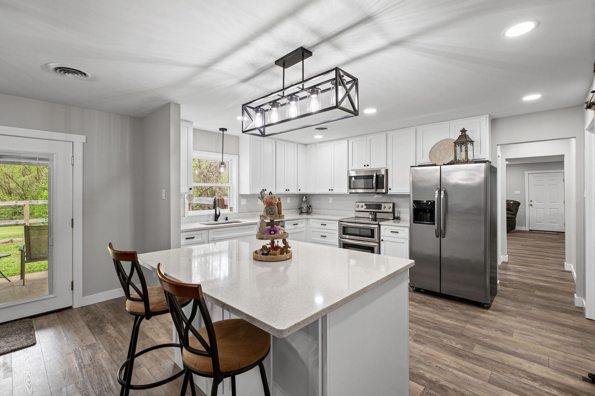 58 Hayes Road Munford, TN 38058 - Photo 10 of 40 Kitchen featuring stainless steel appliances, dark wood-type flooring, white cabinets, and a breakfast bar area