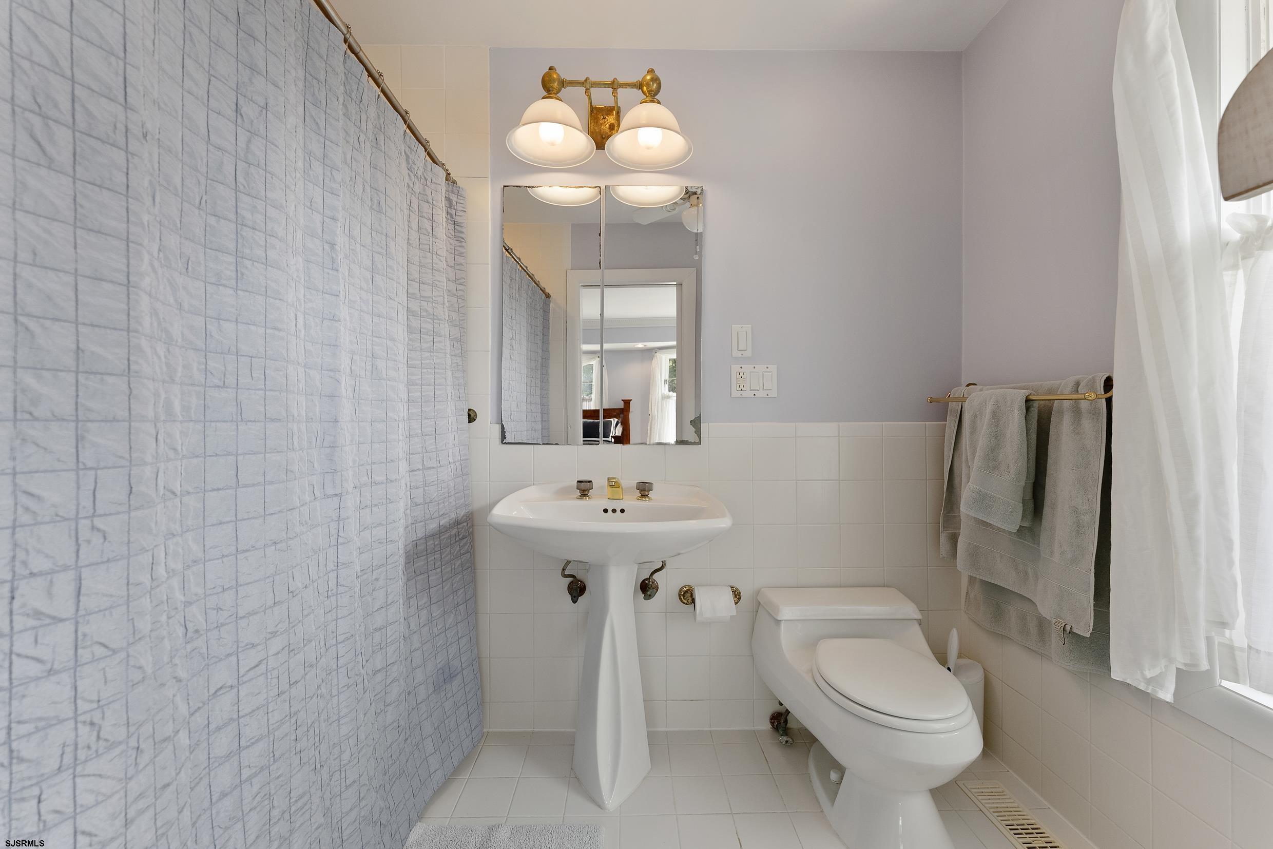 2024 Shore Road Linwood, NJ 08221 - Photo 30 of 51 a bathroom with a sink a toilet and mirror