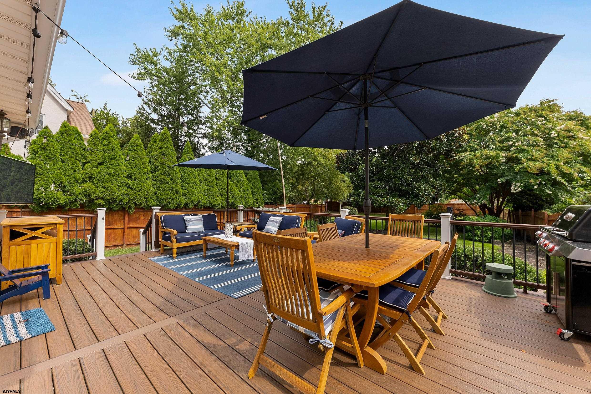 2024 Shore Road Linwood, NJ 08221 - Photo 40 of 51 a view of a roof deck with table and chairs under an umbrella with wooden floor