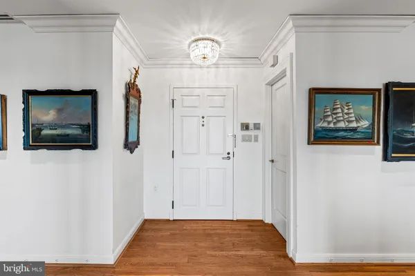 a view of a living room with wooden floor and a flat screen tv