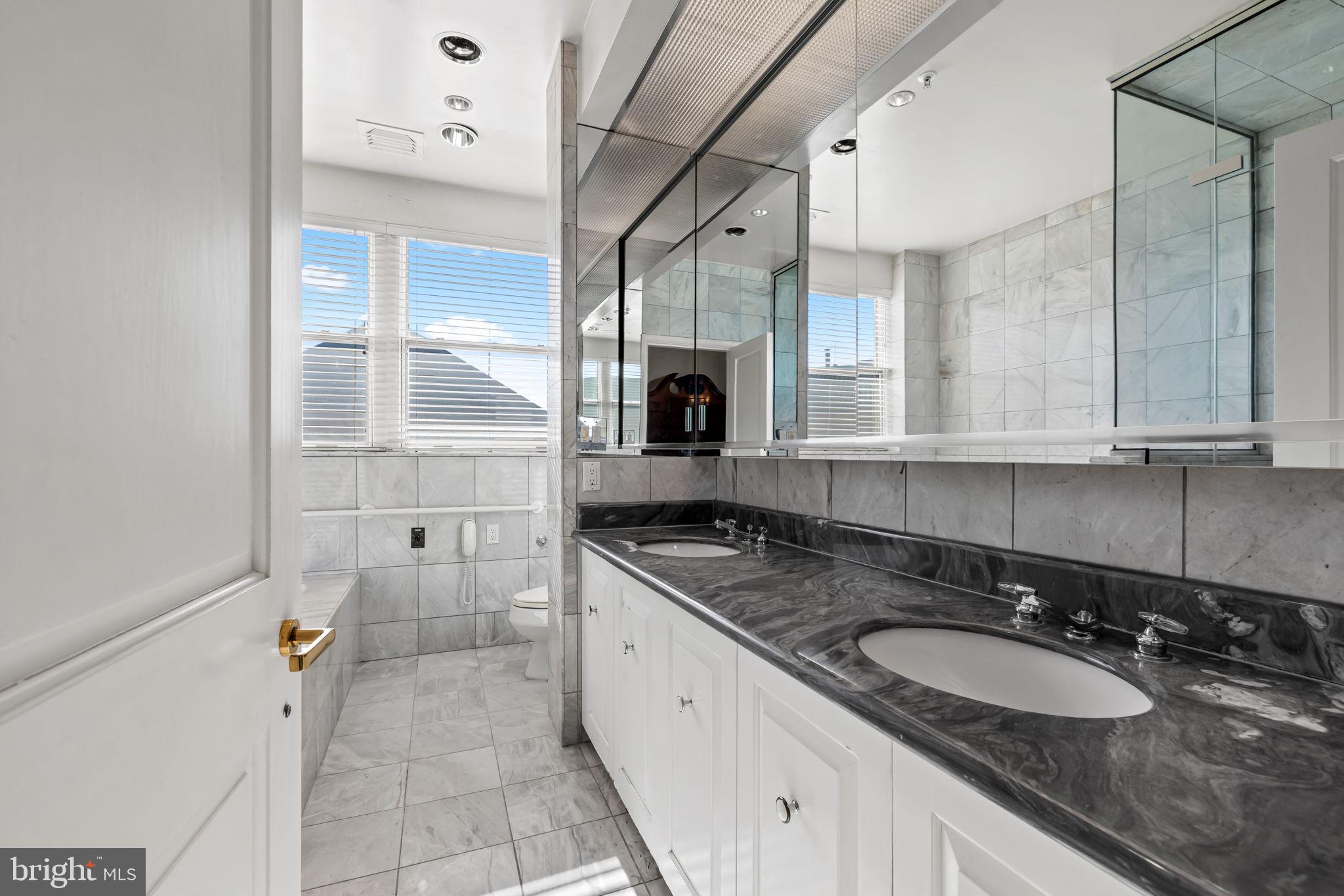 3801 Canterbury Road, Unit 1104 Baltimore, MD 21218 - Photo 33 of 74 a bathroom with a granite countertop double vanity sink a mirror and a bathtub