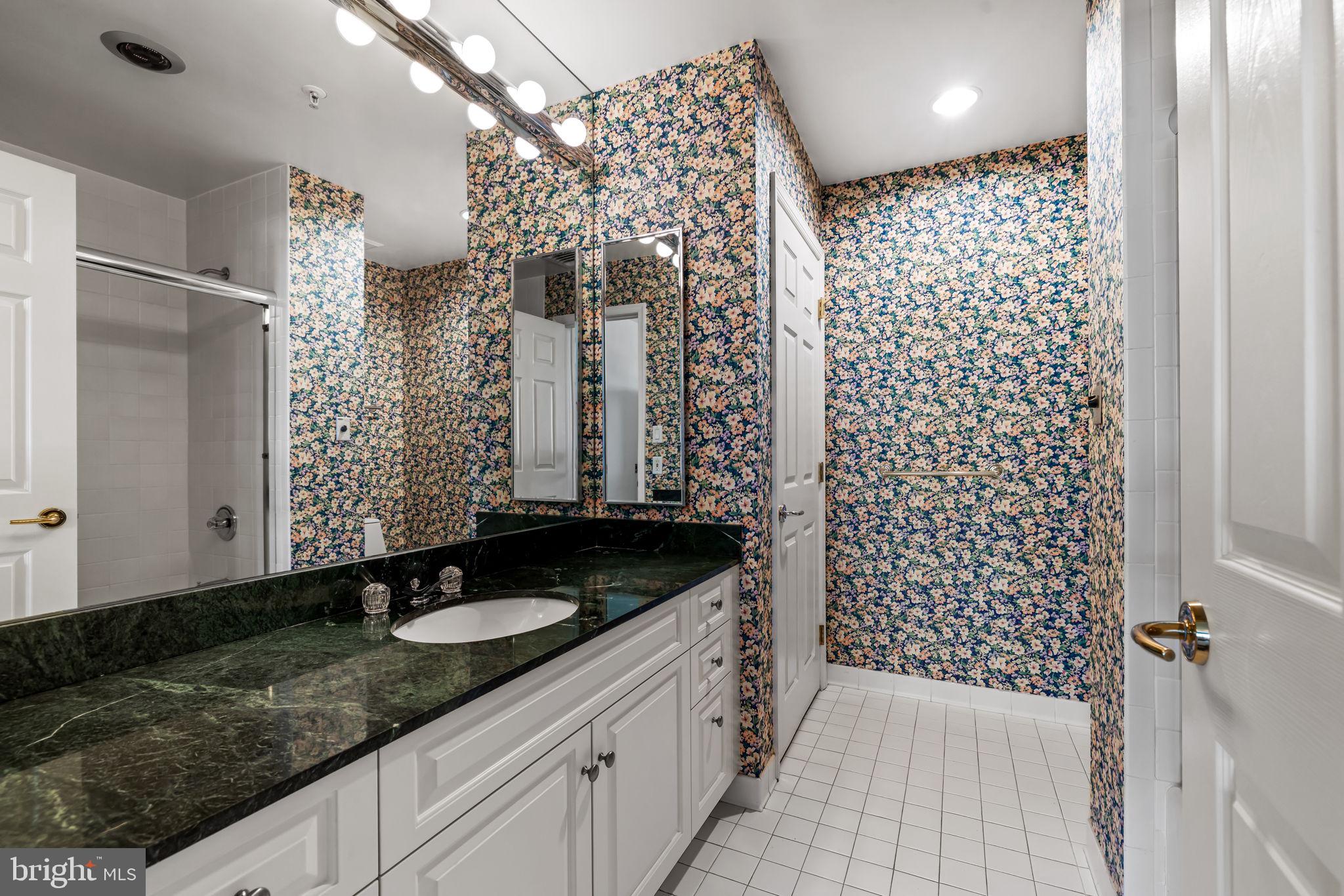 3801 Canterbury Road, Unit 1104 Baltimore, MD 21218 - Photo 53 of 74 a bathroom with a granite countertop sink a shower and a mirror