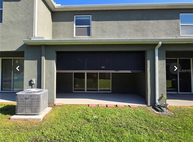 a view of a house with a large window and plants