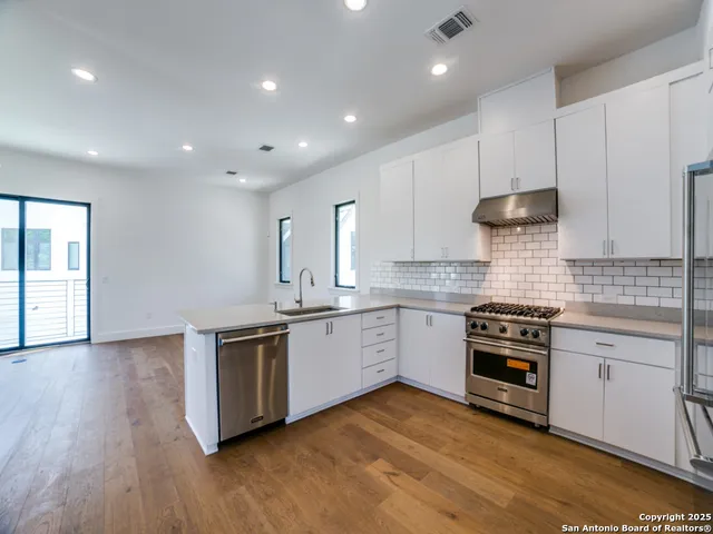 a kitchen with stainless steel appliances granite countertop wooden cabinets and a sink