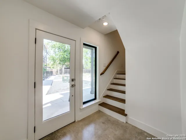 a view of a hallway with wooden floor and entryway