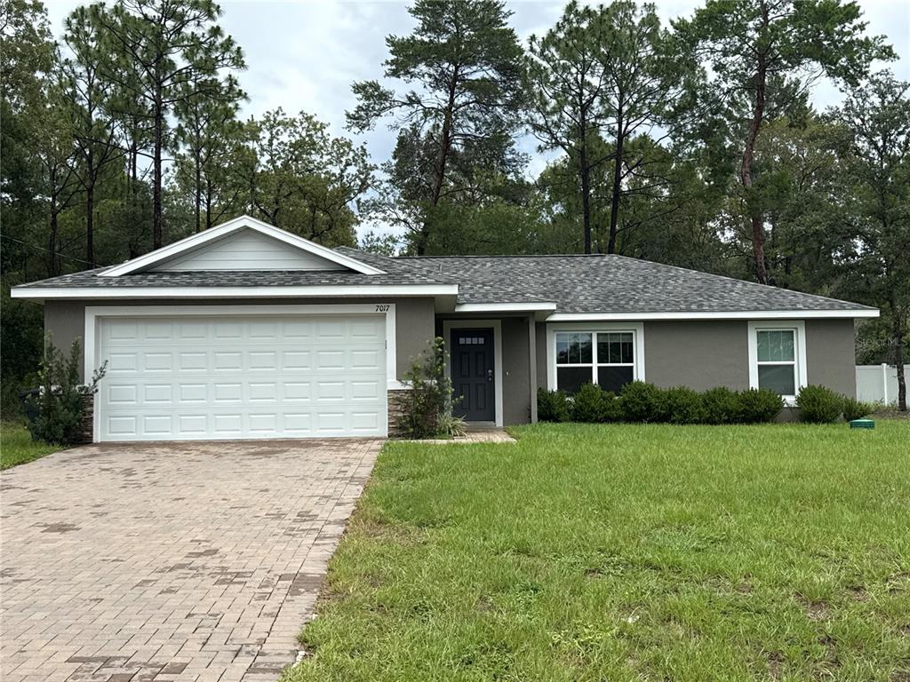 7017 Hemlock Road Ocala, FL 34472 - Photo 1 of 1 a front view of a house with a garden and yard