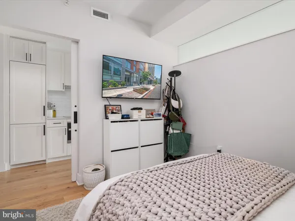 a bedroom with a bed and a flat tv screen on the dresser
