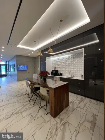 a living room with stainless steel appliances kitchen island granite countertop a sink a counter top space and furniture