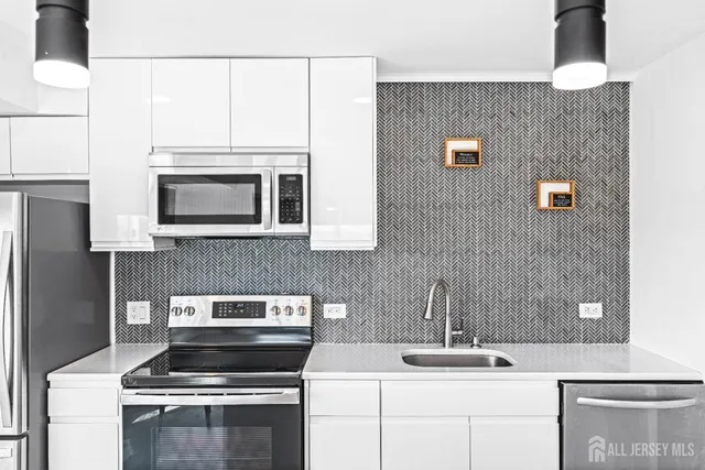 a kitchen with stainless steel appliances a stove microwave and sink