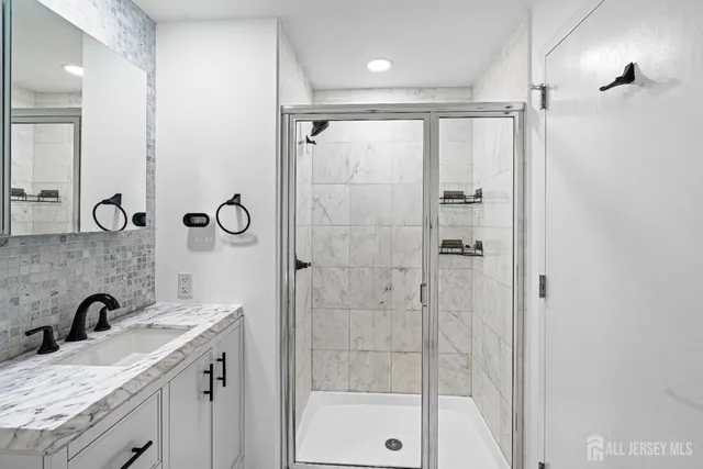 a bathroom with a granite countertop sink mirror and shower