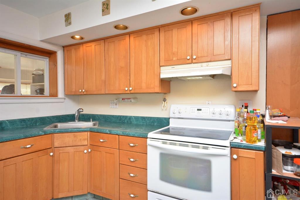 355 Metlars Lane Piscataway, NJ 08854 - Photo 22 of 29 a kitchen with granite countertop a white stove top oven sink and cabinets
