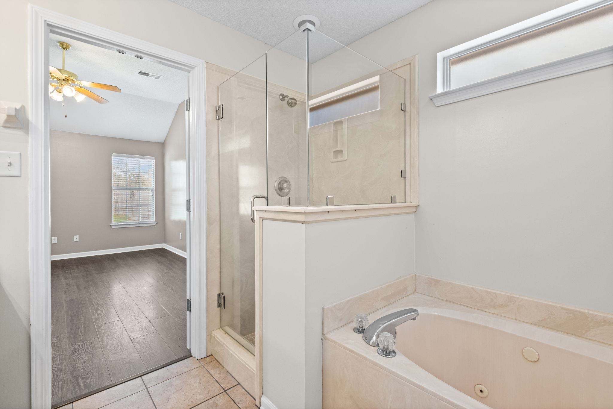 10018 Cameron Ridge Trail Memphis, TN 38016 - Photo 19 of 29 a bathroom with a bathtub and a shower