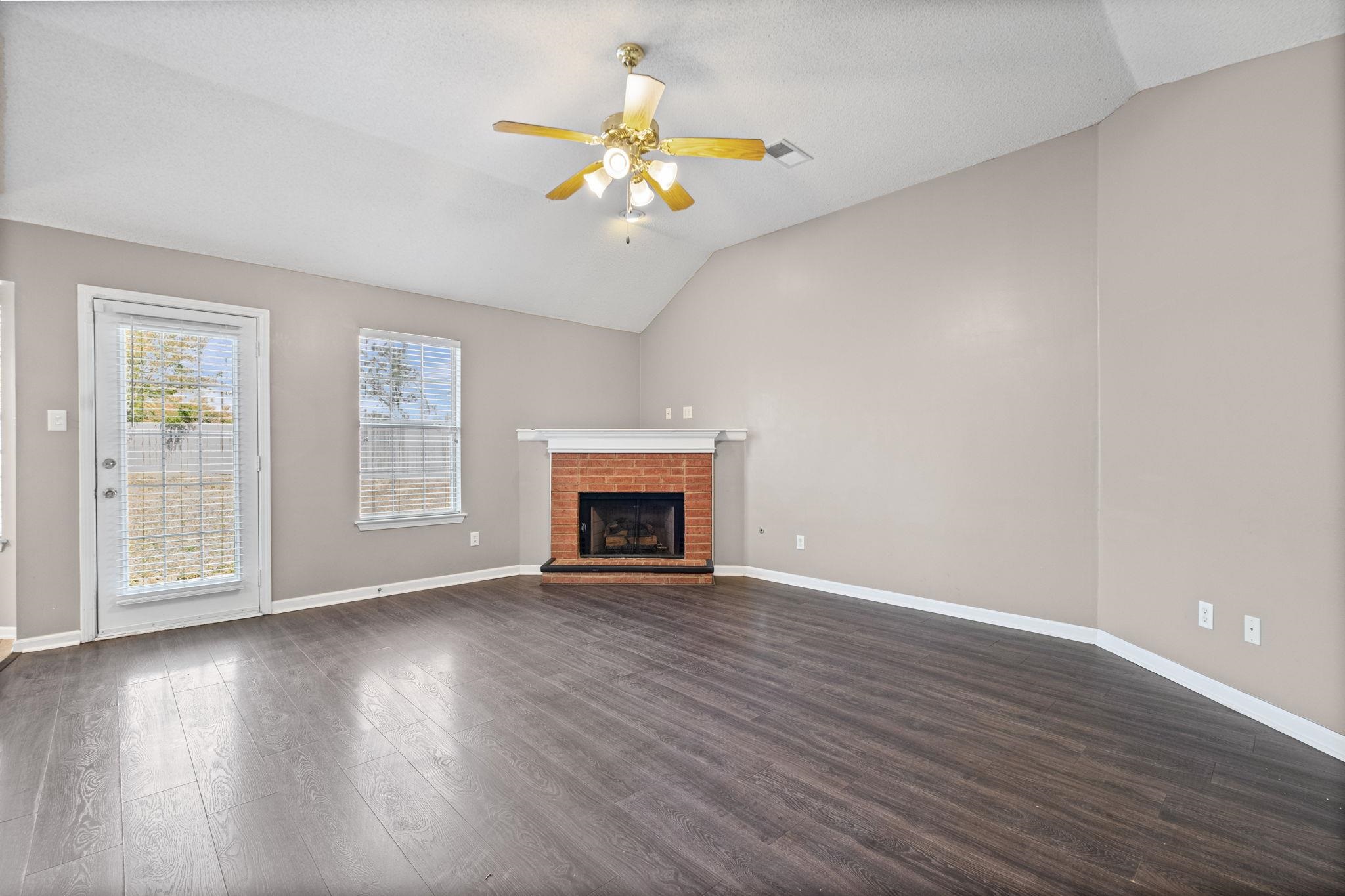 10018 Cameron Ridge Trail Memphis, TN 38016 - Photo 4 of 29 a view of an empty room with wooden floor and a window