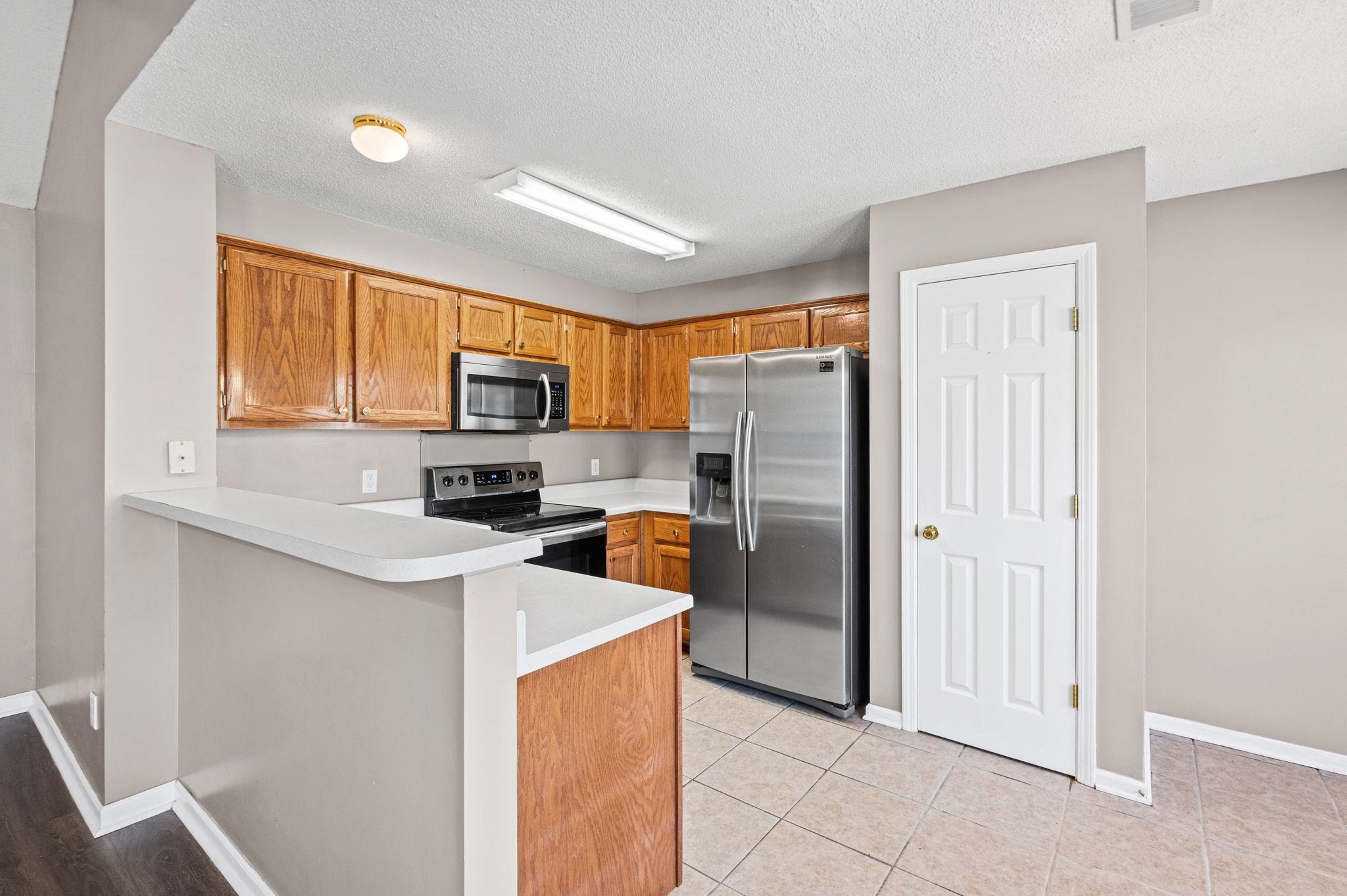 10018 Cameron Ridge Trail Memphis, TN 38016 - Photo 6 of 29 a kitchen with stainless steel appliances a refrigerator and a stove top oven