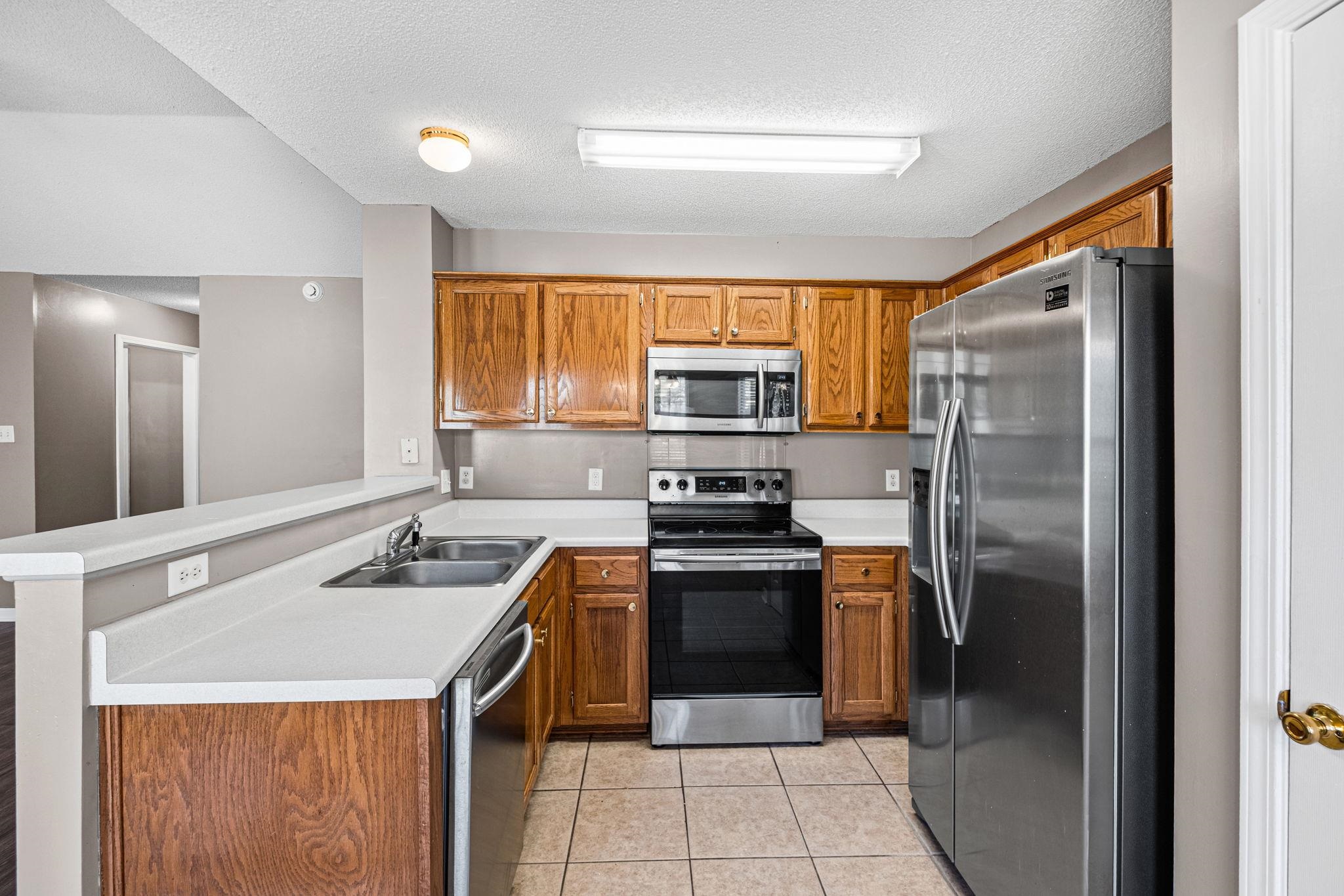 10018 Cameron Ridge Trail Memphis, TN 38016 - Photo 8 of 29 a kitchen with stainless steel appliances granite countertop a sink stove refrigerator and cabinets