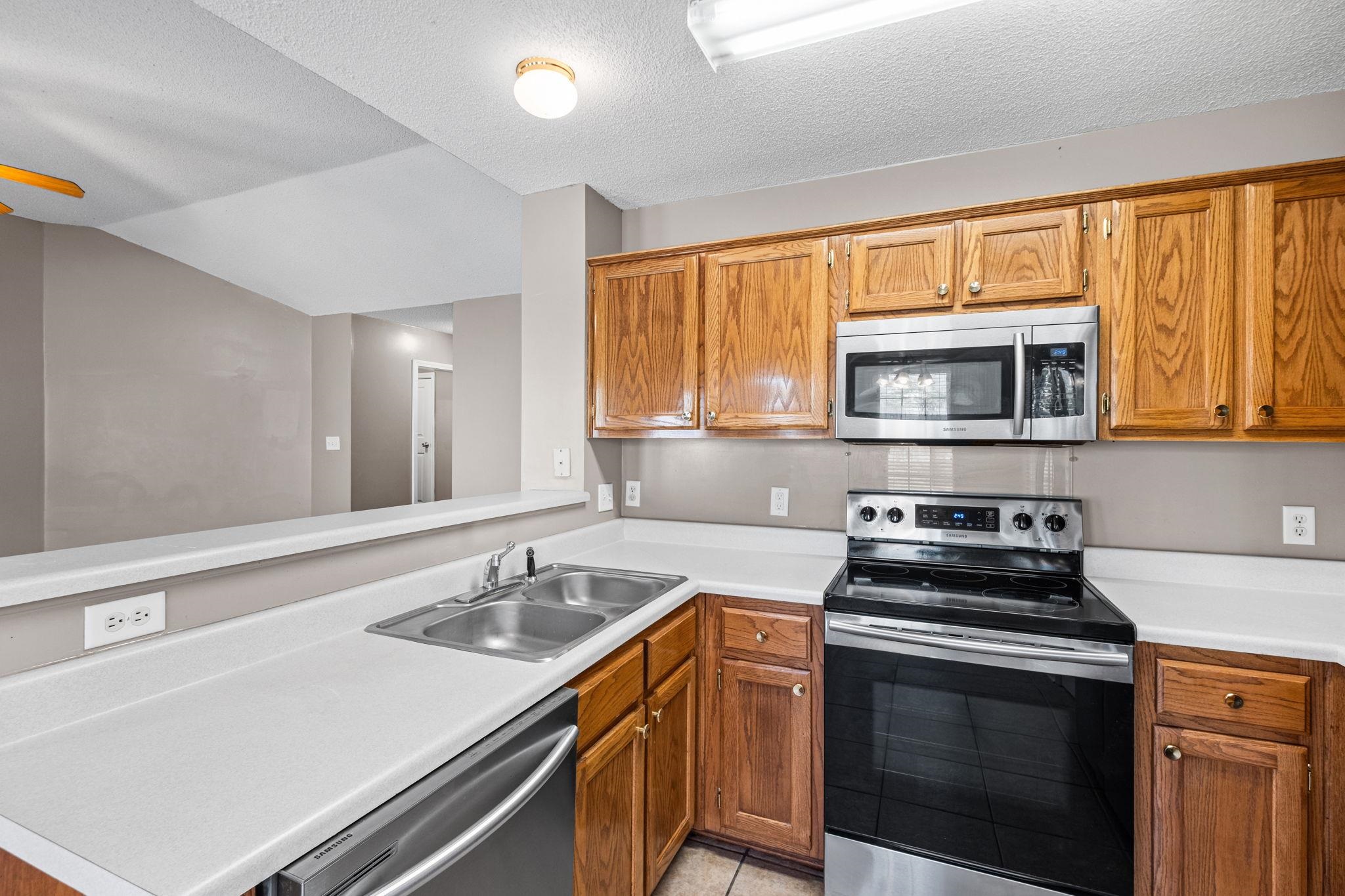 10018 Cameron Ridge Trail Memphis, TN 38016 - Photo 9 of 29 a kitchen with stainless steel appliances a stove sink microwave and cabinets