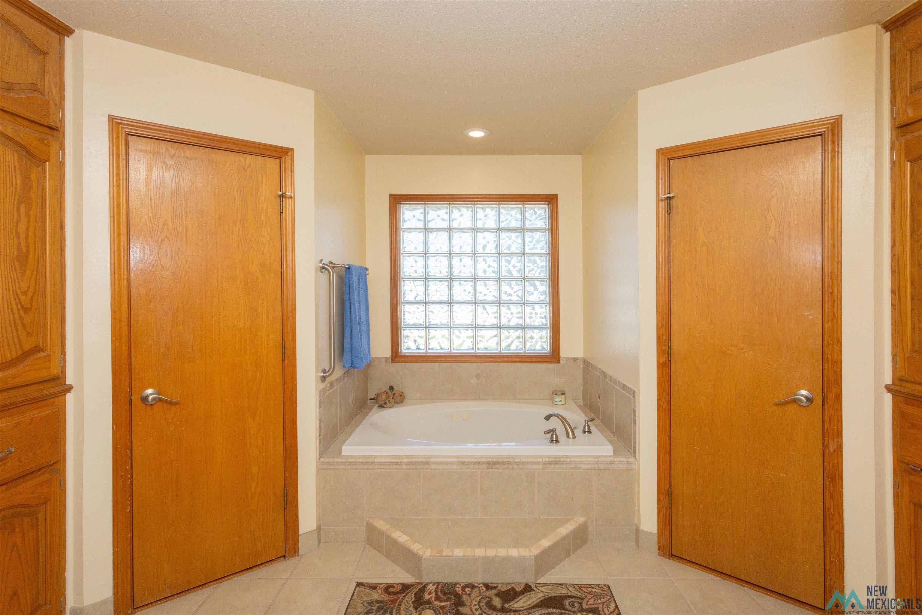 2012 South Haldeman Road Artesia, NM 88210 - Photo 49 of 96 Soaking tub with tiled surround and glass block window. His and Hers walk in closets.