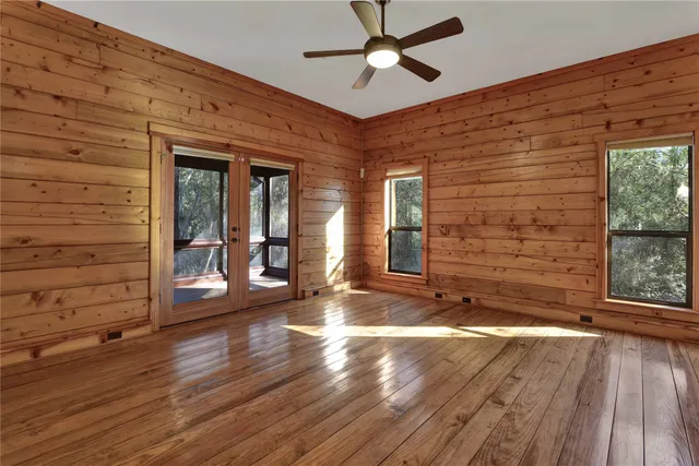 a view of a livingroom with wooden floor and a ceiling fan