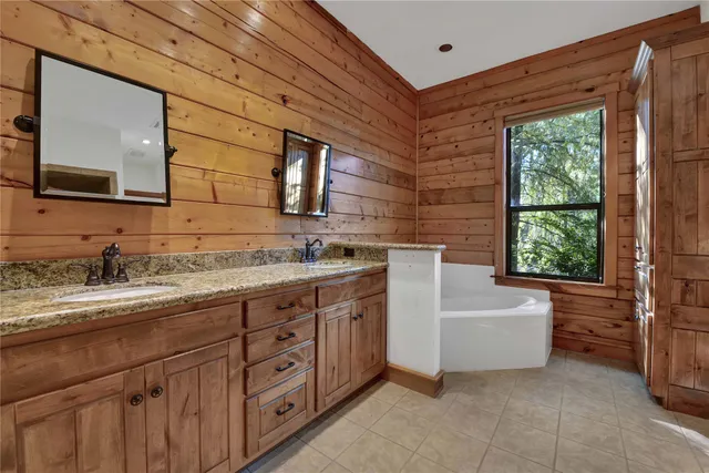 a bathroom with a granite countertop sink mirror and bathtub