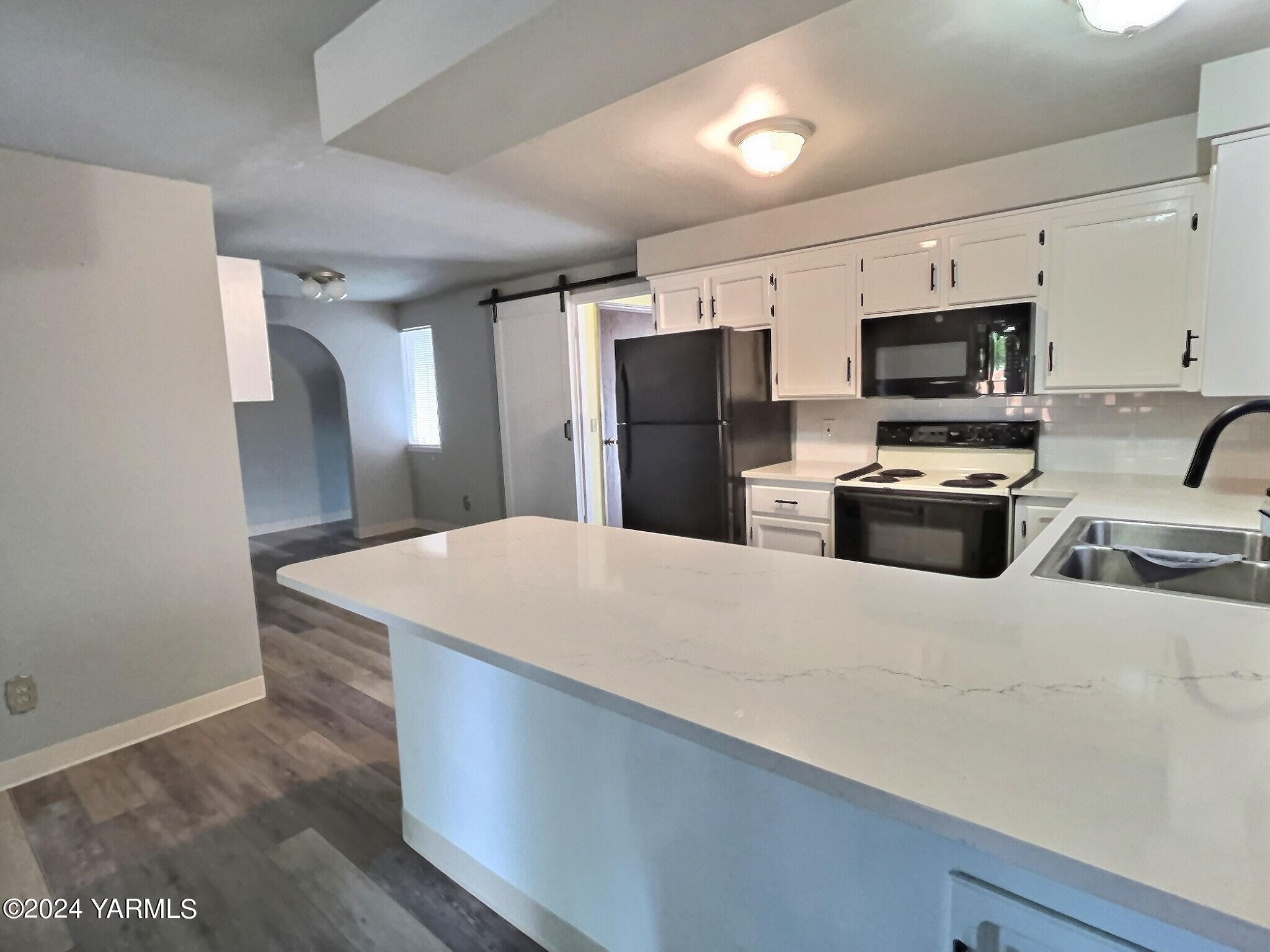 408 Wyant Way Grandview, WA 98930 - Photo 17 of 46 a kitchen with stainless steel appliances a refrigerator and a stove top oven