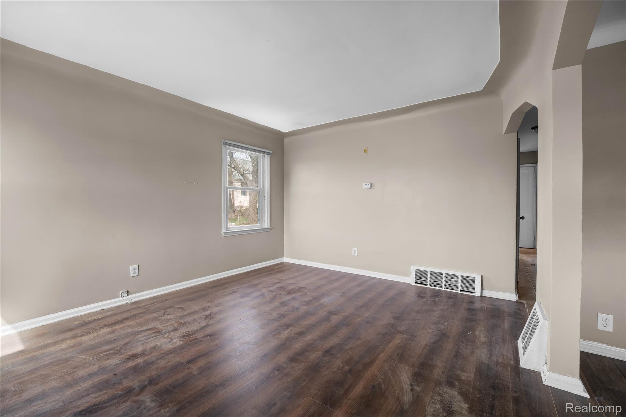 4049 Williams Street Inkster, MI 48141 - Photo 5 of 21 Spare room featuring arched walkways and dark wood-type flooring