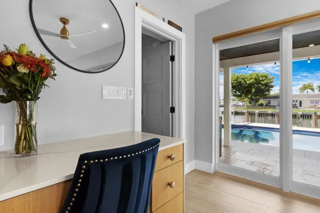 a dining room with wooden floor and a floor to ceiling window