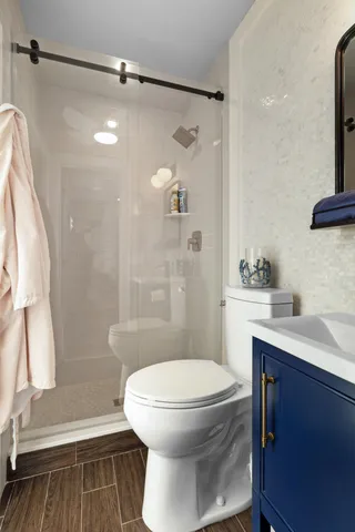 a bathroom with a sink a toilet and shower