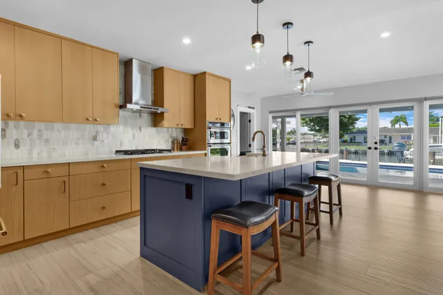 a kitchen with kitchen island granite countertop wooden floors and white cabinets