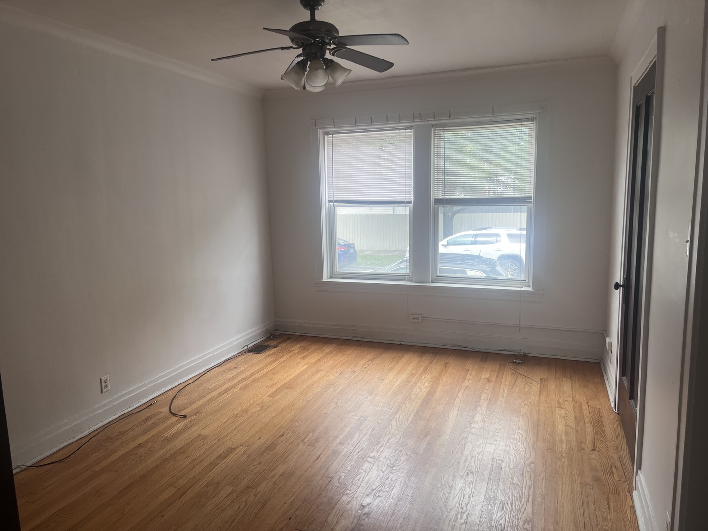 5907 West Arthington Street, Unit 1 Chicago, IL 60644 - Photo 7 of 16 an empty room with wooden floor fan and windows