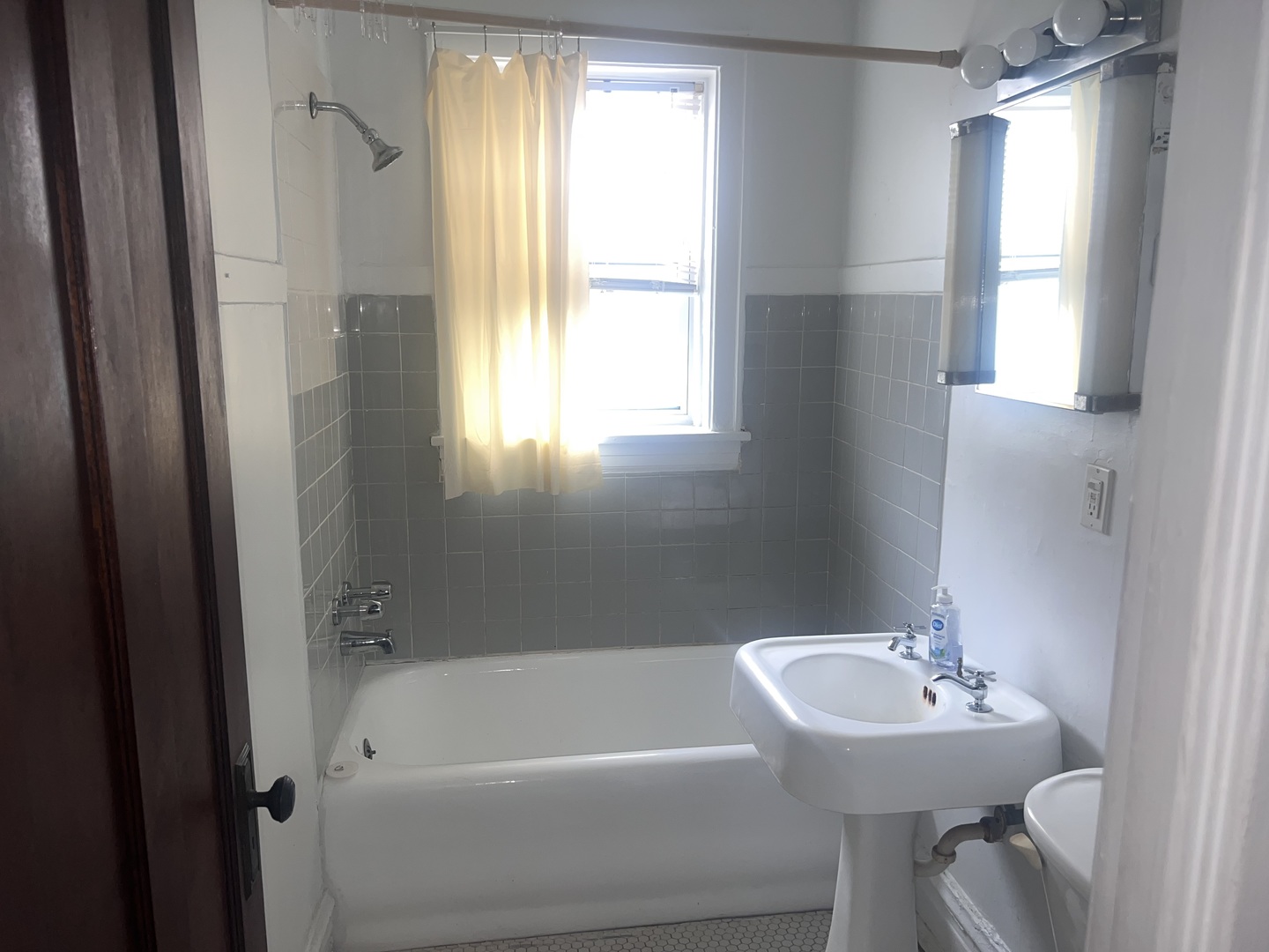 5907 West Arthington Street, Unit 1 Chicago, IL 60644 - Photo 12 of 16 a bathroom with a sink a mirror and a tub