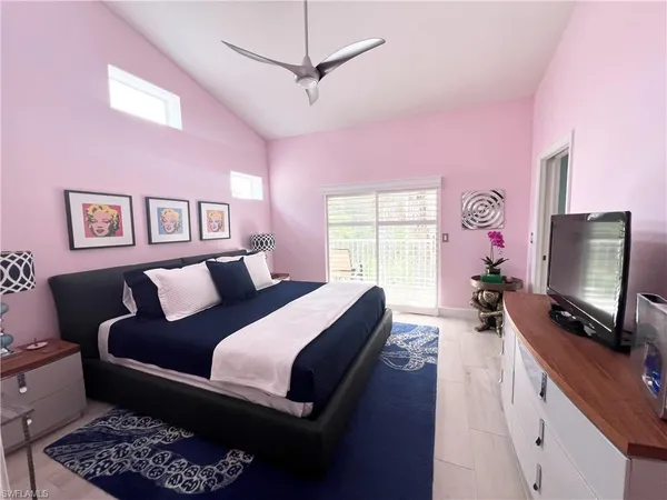 a spacious bedroom with a bed a couch and a flat screen tv