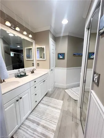 a spacious bathroom with a double vanity sink a mirror and a shower