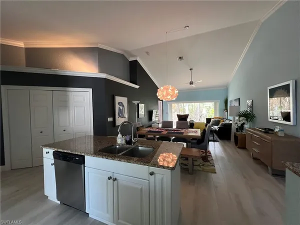 a living room with furniture kitchen view and a window