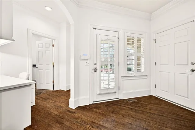 a view of an empty room with wooden floor fireplace and a window