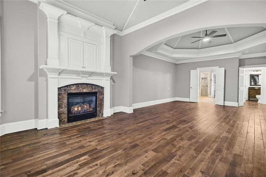 2910 Creek Tree Lane Cumming, GA 30041 - Photo 39 of 75 a view of an empty room with wooden floor fireplace and a window
