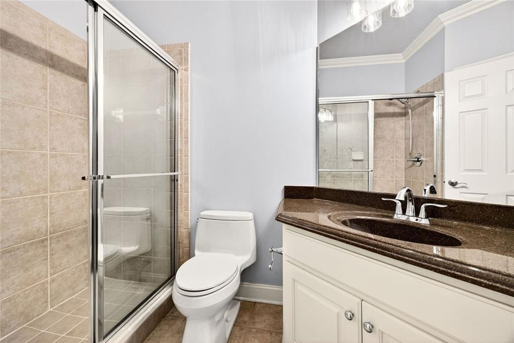 2910 Creek Tree Lane Cumming, GA 30041 - Photo 45 of 75 a bathroom with a granite countertop sink a toilet and a mirror