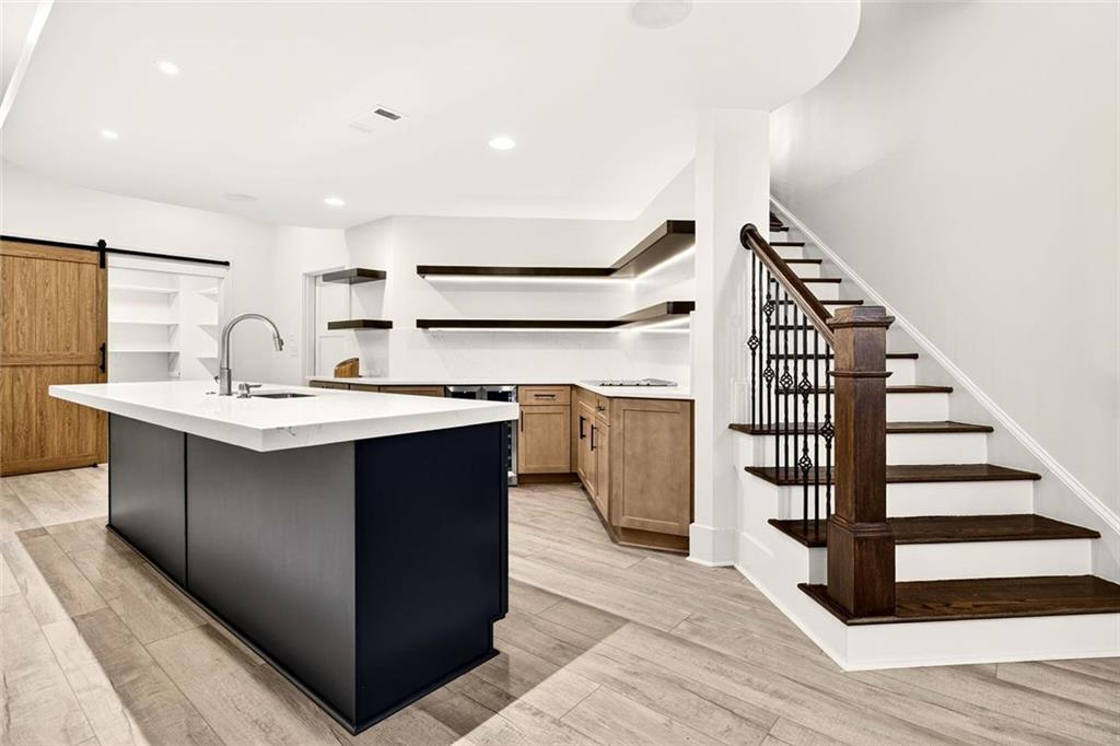 2910 Creek Tree Lane Cumming, GA 30041 - Photo 57 of 75 a kitchen with kitchen island a sink and a stove with wooden floor