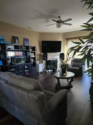 a living room with furniture a flat screen tv and a fireplace