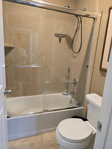 a white toilet and tub sitting next to a bathroom sink