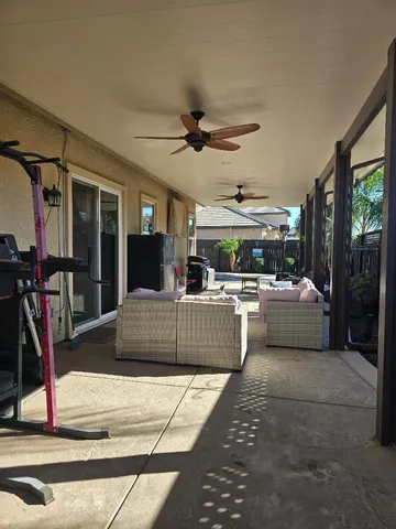 a living room with furniture a ceiling fan and a rug