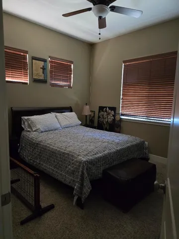 a bedroom with a bed and a ceiling fan