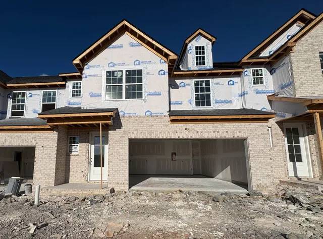 a front view of a house with yard and parking